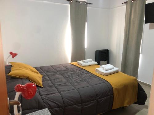 a bedroom with a large bed with towels on it at Patagonia Cordilleras in Esquel