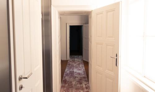 a hallway with white doors and a rug at Elias Residence Vienna in Vienna