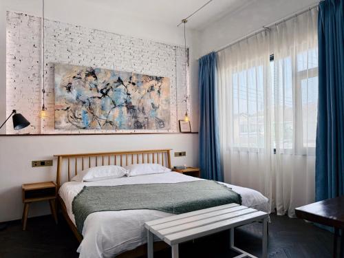 ein Schlafzimmer mit einem Bett und einem Gemälde an der Wand in der Unterkunft Suzhou Unique Space Design Art Hotel in Suzhou