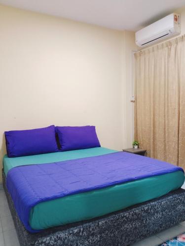 a bedroom with a bed with purple and blue sheets at Iris 2 Bedroom Pool View Balcony in Kampong Tanah Merah