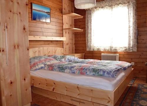a bedroom with a bed in a wooden cabin at Almhaus Am Hohenwart In Klippitztörl in Klippitztorl