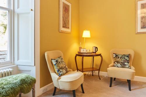 a room with two chairs and a table and a lamp at Merlindale in Crieff