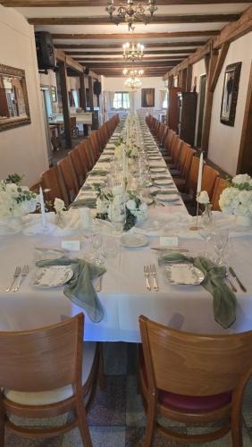 a long table with white tables and chairs at Areal Botanika in Unhošť