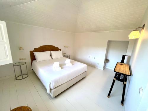 a bedroom with a large white bed with two pillows at Quinta de Sá in Vila Nova de Gaia