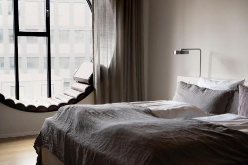 a bedroom with a bed and a large window at Hotel Ottilia in Copenhagen