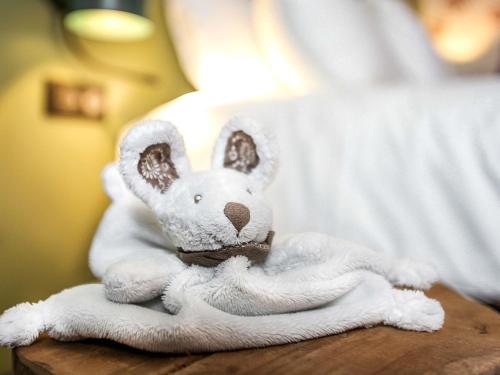 a white stuffed rabbit sitting on a table at Ibis Styles Lisieux Normandie in Lisieux
