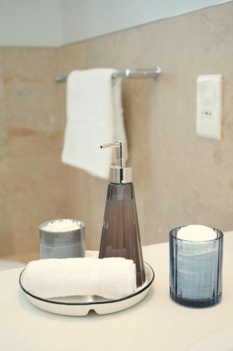 a bathroom counter with a soap dispenser and a towel at Modern Family Golf Lodge in Winelands Paradise in Paarl