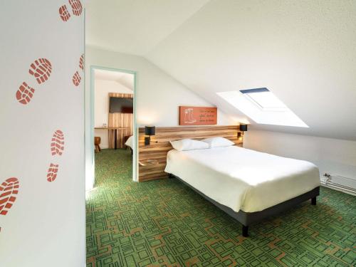 a bedroom with a bed and a skylight at Ibis Styles Lisieux Normandie in Lisieux