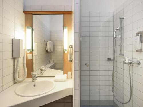 a bathroom with a sink and a shower at ibis Chur in Chur