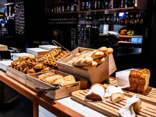 a bunch of different types of bread on a table at ibis Paris Bercy Village in Paris