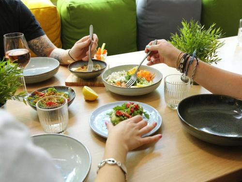 a group of people sitting at a table eating food at ibis Paris Bercy Village in Paris