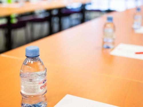 a bottle of water sitting on top of a table at ibis Paris Bercy Village in Paris