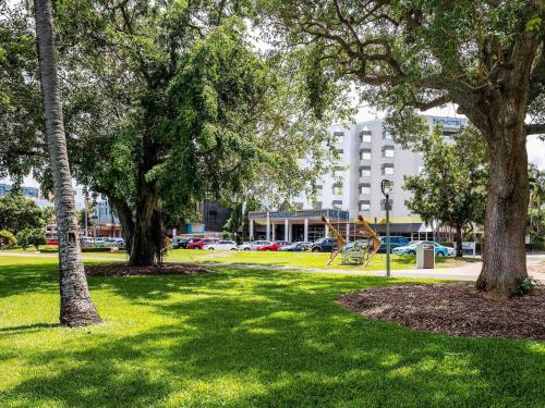 a park with a playground and trees and a building at Novotel Darwin CBD in Darwin