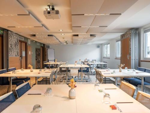 a large room with tables and chairs and windows at Novotel Paris Gare De Lyon in Paris