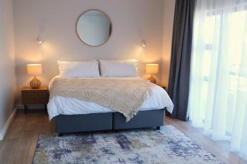 a bedroom with a bed with a mirror on the wall at Modern Family Golf Lodge in Winelands Paradise in Paarl