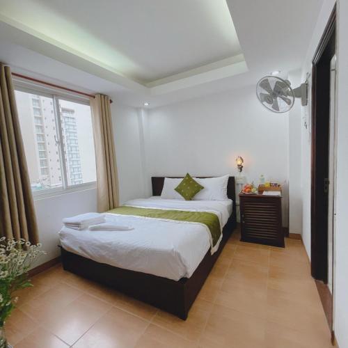 a bedroom with a bed and a window at Hola Nha Trang hotel in Nha Trang