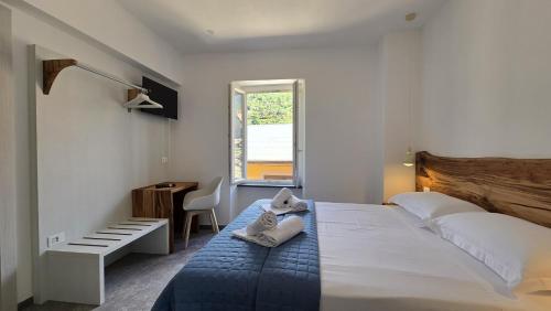 a bedroom with a large bed with towels on it at LA PIAZZETTA - Homy 5 Terre in Volastra