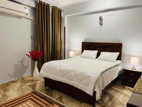 a bedroom with a large bed and a vase of flowers at joy house in Luxor