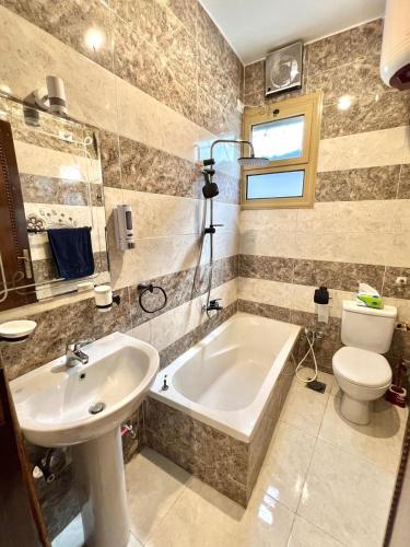 a bathroom with a tub and a toilet and a sink at joy house in Luxor
