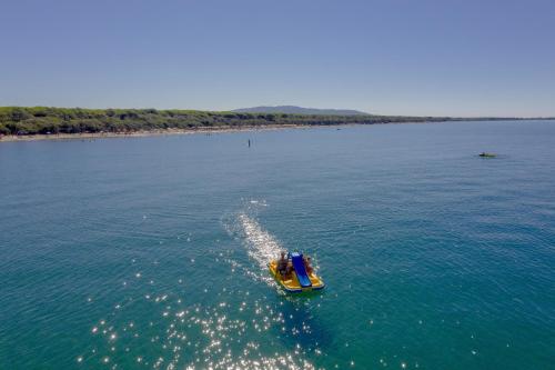 un pequeño barco en medio del agua en Residence with swimming pool in Albinia just 150 mt from the beach, en Albinia