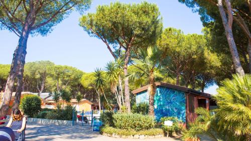 Una casa con una pintura azul en el costado. en Residence with swimming pool in Albinia just 150 mt from the beach, en Albinia
