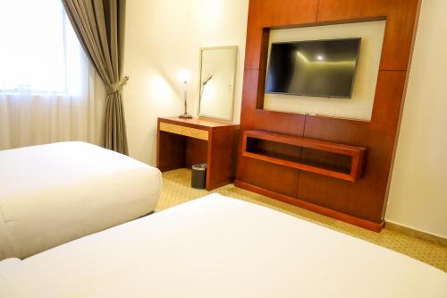 a hotel room with two beds and a flat screen tv at Best Day Hotel and Resorts المحمدية in Jeddah