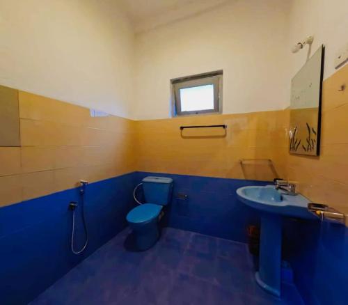 a blue bathroom with a toilet and a sink at Susha Happy One First Floor Apartment in Hikkaduwa