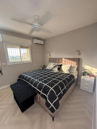 a bedroom with a bed with a black and white comforter at Luxe on Dolev in Beit Shemesh