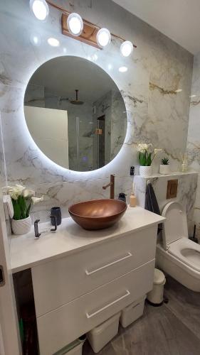 a bathroom with a wooden bowl sink on a counter at Luxe on Dolev in Beit Shemesh
