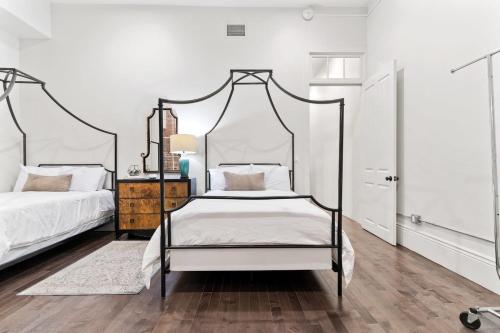 1 Schlafzimmer mit 2 Betten und weißen Wänden in der Unterkunft Group-friendly Nola Suite Near Bourbon in New Orleans