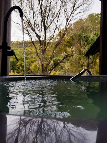 a bath tub with a water fountain at Refugio Poço do Cânion in Barracão