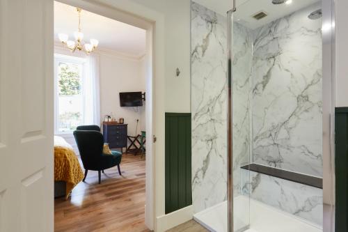 a bathroom with a shower with a glass door at Merlindale in Crieff