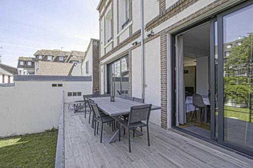 Una terraza de madera con una mesa y sillas. en House for 18 people with cinema Place Morny, en Deauville