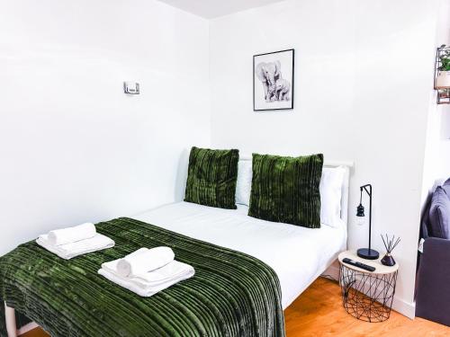 プジーにあるChic Studio, Free parking, Sleeps 2のベッドルーム1室(ベッド1台、緑のシーツ、タオル付)
