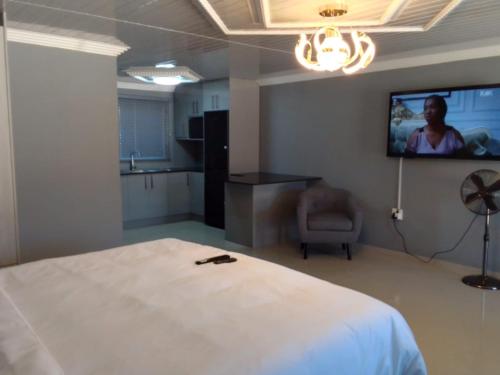 a bedroom with a bed and a tv on the wall at Tlhaping Guest Lodge in Standerton