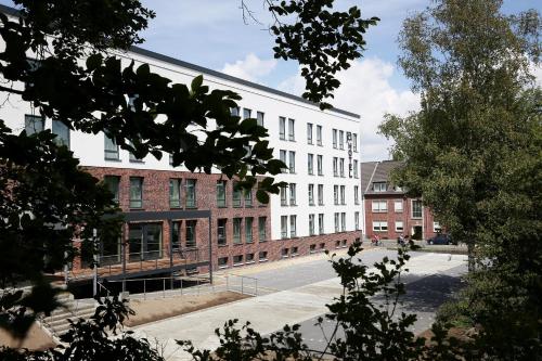 a large white building on the side of a street at JaHotel in Geldern
