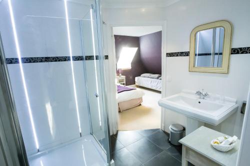 a bathroom with a shower and a sink and a bed at Château de Bellefontaine - Teritoria in Bayeux
