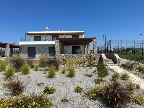 a house in the desert with plants in front of it at Villa Milan 1 mit Padelplatz in Kos Town