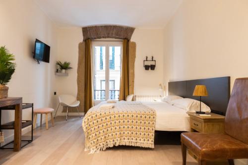 サン・セバスティアンにあるAmona Teresa Guesthouseの大きなベッドと窓のある寝室