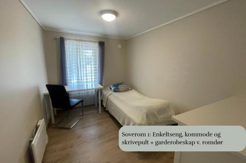 a bedroom with a bed and a desk and a window at Spacious apartment with 4 bedrooms in Grimstad
