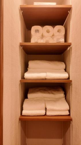 a closet with a bunch of towels on a shelf at Wabisabi Home official汐和 in Wada