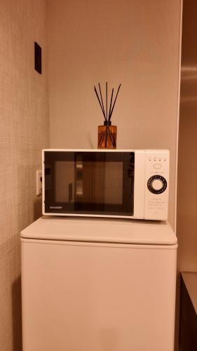 a microwave sitting on top of a refrigerator at Wabisabi Home official汐和 in Wada
