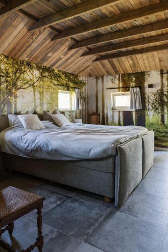 a large bed in a room with a wooden ceiling at Landgoed Boneman in Meddoo
