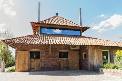an old brick building with a roof on top at Landgoed Boneman in Meddoo
