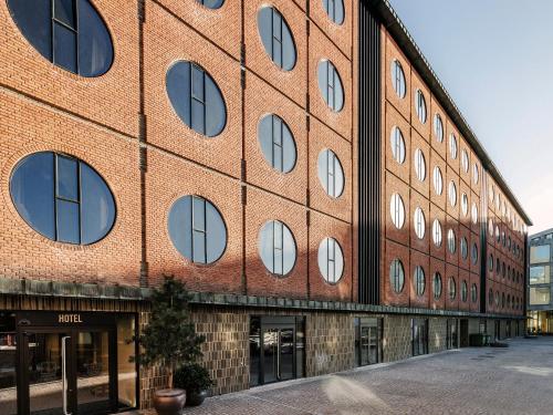 a brick building with many windows on a street at Hotel Ottilia in Copenhagen