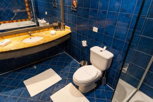 a blue tiled bathroom with a toilet and a sink at Porto Marina Resort & Spa Al Alamein in El Alamein
