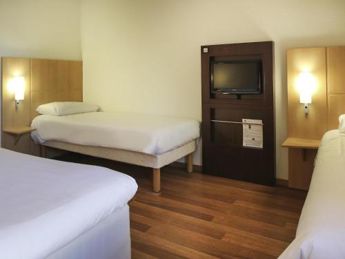 Ένα ή περισσότερα κρεβάτια σε δωμάτιο στο ibis Bourg Jasseron/Teyssonge