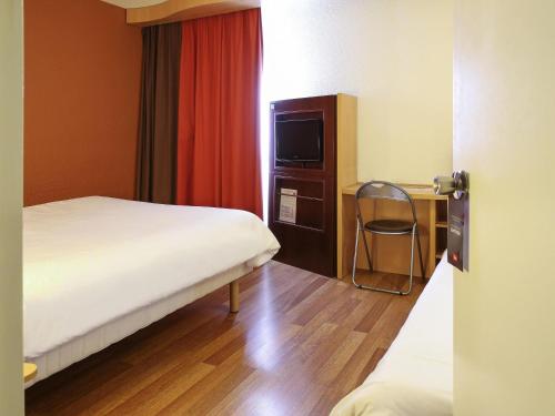 Ένα ή περισσότερα κρεβάτια σε δωμάτιο στο ibis Bourg Jasseron/Teyssonge