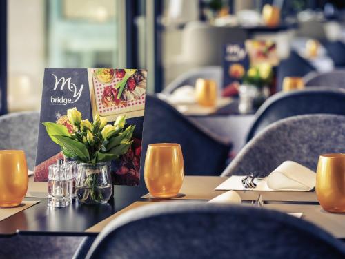 a table in a restaurant with a vase of flowers at Mercure Budapest Korona in Budapest