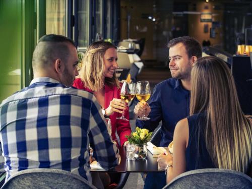 a group of people sitting around a table drinking wine at Mercure Budapest Korona in Budapest